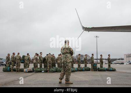 HANSCOM AIR FORCE BASE, Mass. - Members of C Company 1-181st Infantry Regiment, Massachusetts National Guard load baggage prior onto the plane that will take them to the first stop of their deployment. Stock Photo