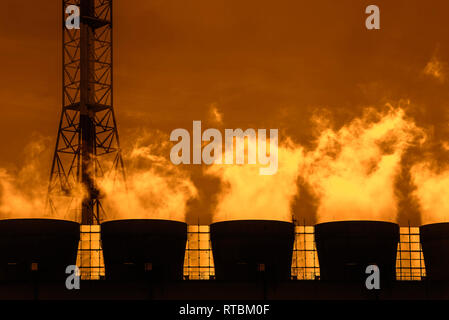 Smoke from chimneys at sunset at industrial estate showing BASF chemical production site in the port of Antwerp, Belgium Stock Photo