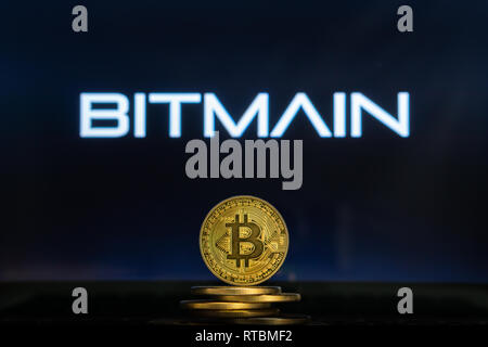 Bitcoin on a stack of coins with Bitmain logo on a laptop screen. Cryptocurrency and blockchain adoption getting mainstream. Slovenia - 02 24 2019 Stock Photo