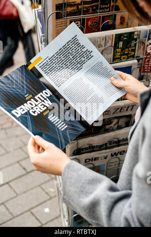 STRASBOURG, FRANCE - OCT 28, 2017: Woman reading The Economist business magazine at press kiosk  Stock Photo