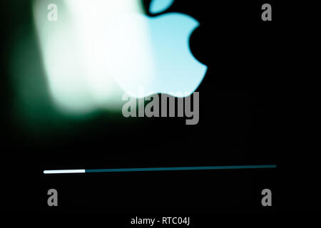 PARIS, FRANCE - SEP 12, 2014: Apple Computers logotype onthe retina screen display of the latest iPad tablet  displaying progess update loading bar in green tones  Stock Photo
