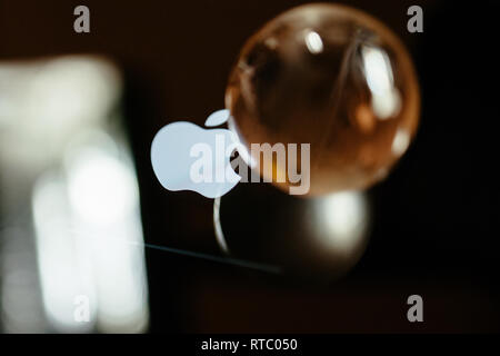 PARIS, FRANCE - SEP 12, 2014: Apple Computers logotype on the retina screen display of the latest iPad tablet  displaying progress update loading bar next to glass globe Stock Photo