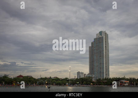 Jakarta, Indonesia - December 9, 2017 : Activities of people at Ancol Beach with Ancol Mansion at the background and lovely skies Stock Photo