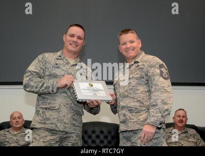 Lt. Col William Young, outgoing 72nd Aerial Port Squadron commander, accepts a plaque from the members of his squadron Feb. 10, 2019, during a change of command ceremony at Tinker Air Force Base, Oklahoma. Young is succeeded by Lt. Col. Darryl McLean as commander of the 72nd APS. Stock Photo