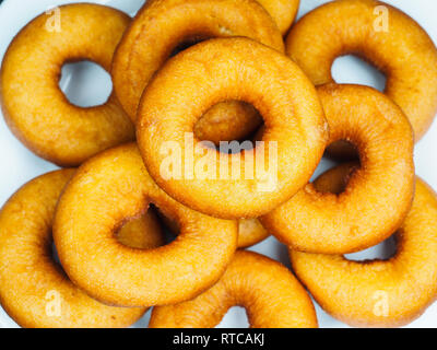 Closeup of a plate of freshly made dark brown doughnuts Stock Photo