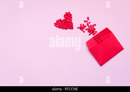 Opened red envelope and many felt hearts on pink background with place for text. Love letter mail correspondence relationship. Valentines day concept. Stock Photo