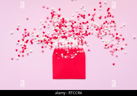 Opened red envelope and many felt hearts on pink background with place for text. Love letter mail correspondence relationship. Valentines day concept. Stock Photo