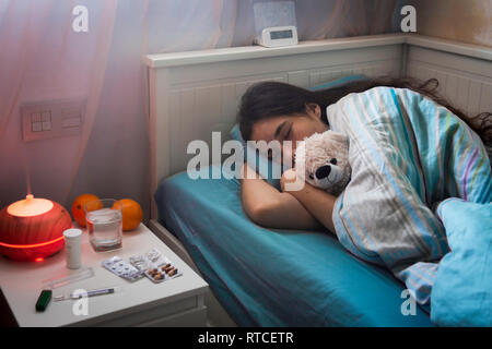 Teenage girl in bed at home caught cold, feeling bad, sleeping. Stock Photo