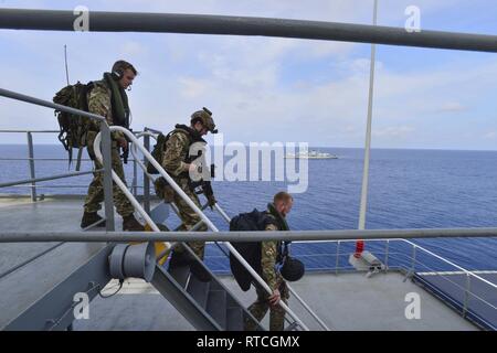 GULF OF THAILAND (Feb. 18, 2019) - Royal Marine commandos and Royal Navy sailors attached to the Duke-class frigate HMS Montrose (F 236) conduct a visit, board, search and seizure (VBSS) drill aboard the Henry J. Kaiser-class fleet replenishment oiler USNS Guadalupe (T-A 200).  During the drill, commandos and sailors coordinated with Guadalupe crew members to simulate maritime interdiction operations and execute proper VBSS procedures. Guadalupe is conducting operations which provides logistical support to U.S. Navy and allied forces operating in the U.S. 7th Fleet area of responsibility. Stock Photo