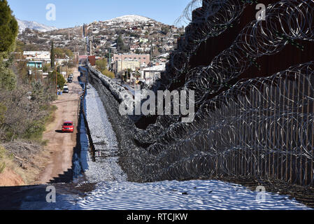 Four rows of concertina wire cover the metal wall in Nogales, Arizona, USA, at the international border with Nogales, Sonora, Mexico. Stock Photo