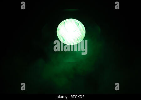 Green light with smoke on dark background. Equipment for photo Studio. Stock Photo