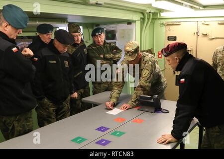 Col. Patrick Michaelis, commander of the Mission Command Element in Poznan, Poland, draws an organizational chart explaining the roles of each unit in a field environment for Maj. Gen. Adam Joks, Deputy Chief of the General Staff of the Polish Armed Forces, and other Polish senior leaders, in the Joint Operations Center, at the MCE Feb. 14.    The purpose of the visit was to gain an understanding of the MCE's command post daily operations.    U.S. forces deployed to Europe in support of Atlantic Resolve is evidence of the strong and unremitting U.S. commitment to NATO and Europe. Through conti Stock Photo