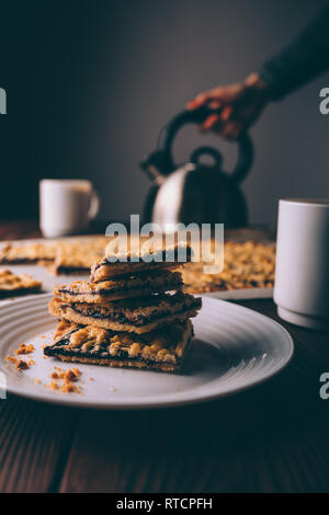 Close-up of stack of cookies next to cup of coffee on rustic background. Stock Photo