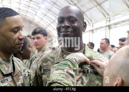 Sgt. Ruel Richards, 1st Theater Sustainment Command, receives his badge during graduation from Air Assault School at Camp Buehring, Kuwait, Feb. 15, 2019. Stock Photo