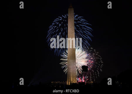 Washington DC, USA - 4 July 2017: Red, white and blue fireworks light the sky behind The Washington Monument, on the mall in DC Stock Photo