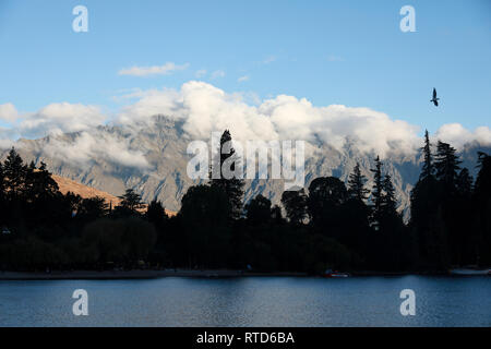 Evening sunset clouds sitting over The Remarkables mountain range near Queenstown, New Zealand South Island with a black billed gull Stock Photo