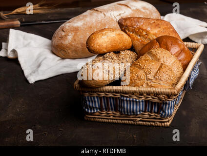 Assortment of baked goods in a basket on dark background Stock Photo