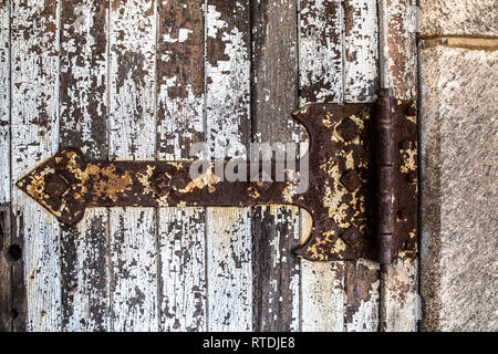 Detailed close-up of rusty old hinge on a door with peeling paint Stock Photo