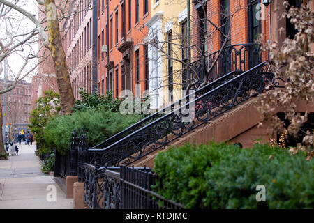View of colorful apartment buildings and brownstones along pretty street in New York City. Stock Photo