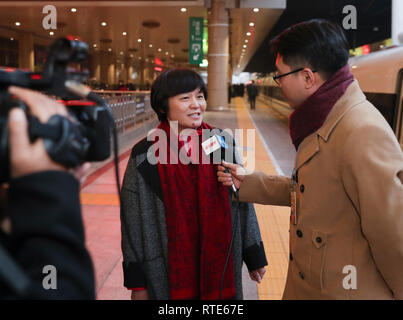 (190301) -- BEIJING, March 1, 2019 (Xinhua) -- Zhang Xiaolian, member of the 13th National Committee of the Chinese People's Political Consultative Conference (CPPCC) from central China's Hubei Province, receives an interview at Beijing West Railway Station upon her arrival in Beijing, capital of China, March 1, 2019, for the second session of the 13th CPPCC National Committee.  (Xinhua/Ding Haitao) Stock Photo