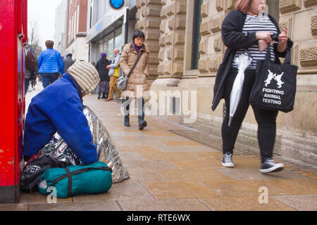 Preston, Lancashire. 1st March 2019. UK Weather. Cold, damp inclement day in the town centre as Preston’s homeless people hope for donations on the city centre streets. Trapped in the social system by having no fixed abode, they are unable to claim Universal Credit and resort to begging to hopefully acquire cash from passing shoppers, enough for a overnight hostel. Credit. MWI/AlamyLiveNews. Stock Photo