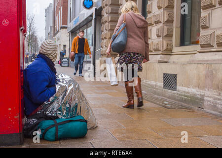 Preston, Lancashire. 1st March 2019. UK Weather. Cold, damp inclement day in the town centre as Preston’s homeless people hope for donations on the city centre streets. Trapped in the social system by having no fixed abode, they are unable to claim Universal Credit and resort to begging to hopefully acquire cash from passing shoppers, enough for a overnight hostel. Credit. MWI/AlamyLiveNews. Stock Photo