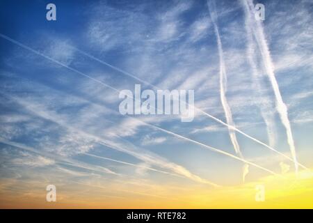 Code Strips in the sky over Schleswig at sunset in the early evening in late winter. In conspiracy theories, these thin clouds caused by airplanes are also referred to as chemtrails. Chemtrail is a portmanteau of the English chemical for chemicals and contrails for contrails, in German so about chemical strips. | usage worldwide Stock Photo