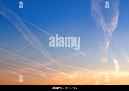 Code Strips in the sky over Schleswig at sunset in the early evening in late winter. In conspiracy theories, these thin clouds caused by airplanes are also referred to as chemtrails. Chemtrail is a portmanteau of the English chemical for chemicals and contrails for contrails, in German so about chemical strips. | usage worldwide Stock Photo