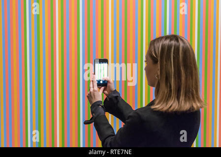 London, UK.  1 March 2019. A staff member views ''Midi'', 1983, by Bridget Riley, (Est. £1,200,000 - 1,800,000).  Preview of Sotheby's Contemporary Art Sale in their New Bond Street galleries.  Works by artists including Tracey Emin, Jenny Saville, Jean-Michel Basquiat and Andy Warhol will be offered for auction on 5 March 2019.   Credit: Stephen Chung / Alamy Live News Stock Photo