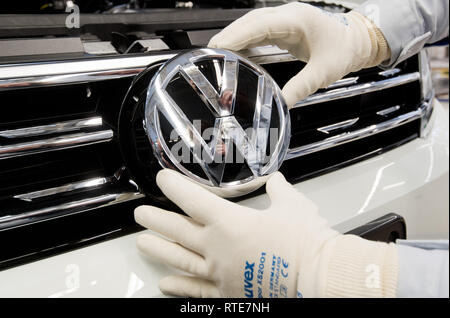 Wolfsburg, Germany. 01st Mar, 2019. An employee mounts a VW logo on the front of a VW Tiguan during final assembly at the VW factory. Credit: Julian Stratenschulte/dpa/Alamy Live News Stock Photo