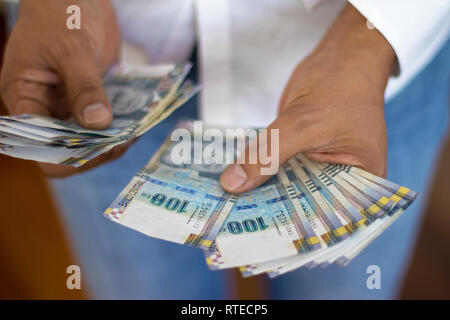 Man counting 100 soles bills, peruvian currency concept, counting bank notes from peru Stock Photo