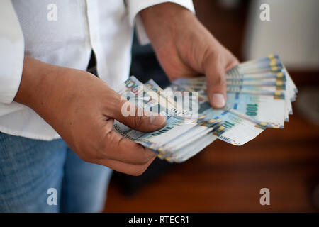 Man counting 100 soles bills, Peruvian currency and salary concept, counting bank notes from Peru Stock Photo