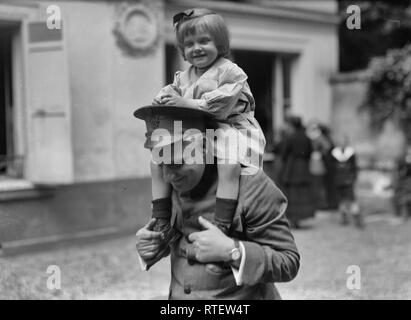 Little Belgian refugee having a good time with an American Red Cross man at an American Hostel for refugees at 46 Rue du Dr. Blanche, Paris. June 1918 Stock Photo