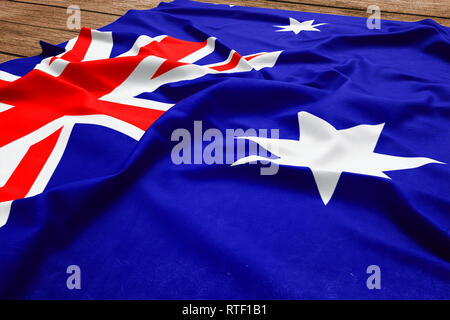 Flag of Heard Island And Mcdonald Islands on a wooden desk background. Silk flag top view. Stock Photo