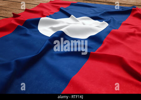 Flag of Laos on a wooden desk background. Silk Laotian flag top view. Stock Photo