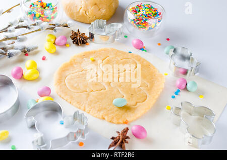 Happy Easter card. Easter biscuits,  cuttings, candy eggs and ingredients for baking rolled dough dough, copy space, top view Stock Photo