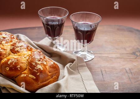 Shabbat concept, challah bread with two glasses of red wine on wooden table, copy space Stock Photo