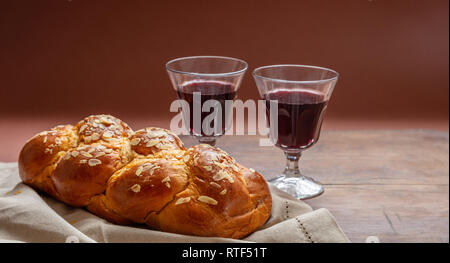 Shabbat concept, challah bread with two glasses of red wine on wooden table Stock Photo