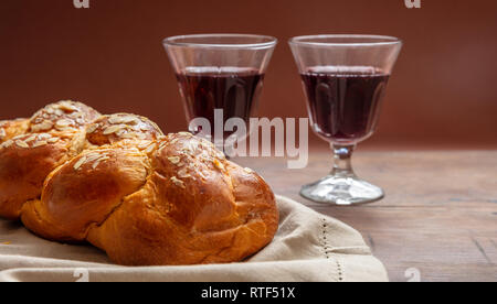 Shabbat concept, challah bread with two glasses of red wine on wooden table Stock Photo