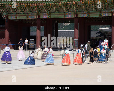 Tourists in hanbok entering and being photographed the entrance of Geongbokgung Palace in Seoul, South Korea. Stock Photo