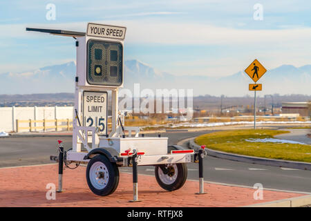 Radar speed display trailer with speed limit sign. A speed limit sign of 25 can also be seen below the display. Stock Photo