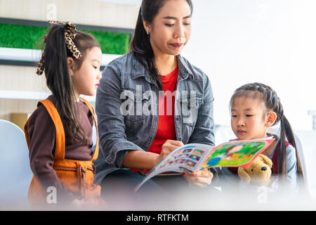 Teacher is reading story book to kindergarten students Stock Photo
