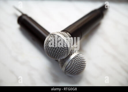 close up two microphone for duo sing a song concept . Two silver microphones isolated over white background Stock Photo