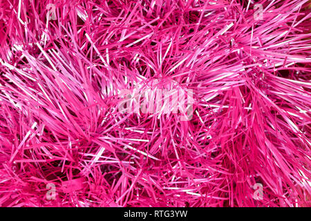 An abstract textured background of close up pink and silver Christmas tinsel Stock Photo