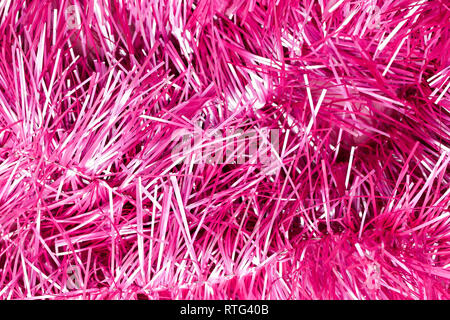 An abstract textured background of close up pink and silver Christmas tinsel Stock Photo