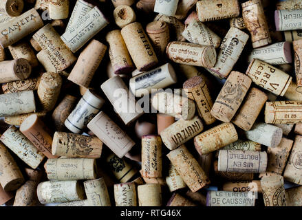 Used wine corks on sackcloth background with empty space for text. Colorful corks from white and red wine bottles Stock Photo