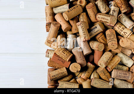 Used wine corks on sackcloth background with empty space for text. Colorful corks from white and red wine bottles Stock Photo