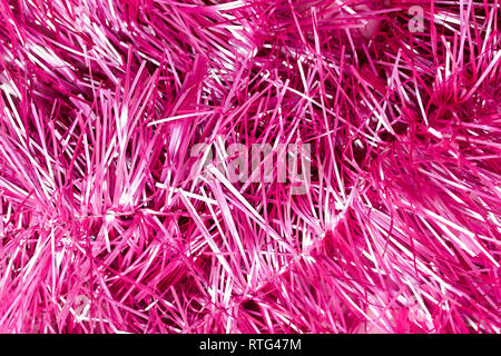 An abstract textured background of close up pink and silver Christmas tinsel Stock Photo