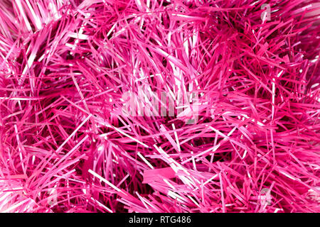 An abstract textured background of close up pink and silver Christmas tinsel Stock Photo