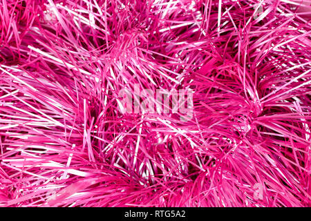 An abstract textured background of close up pink and silver Christmas tinsel Stock Photo